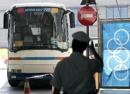 图文-雅典机场重视安全工作 警察指挥大巴车_