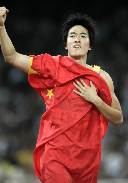 图文-男子110米栏决赛 刘翔在夺冠后抱住国旗