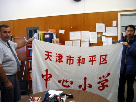 图文:记者向校长赠送天津和平区中心小学旗帜