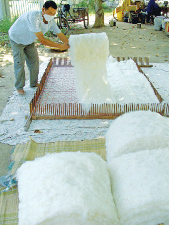 [图文]7月25日,湖北宜昌街头个体商户在加工棉花制作棉被.