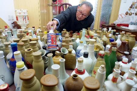 11月18日,家住杭州景芳一区的朱益德摆弄欣赏自己收藏的各式酒瓶