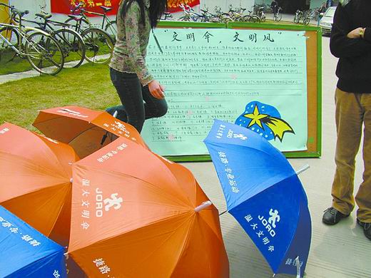 图文:大学校园举办 文明伞 测试文明行为活动