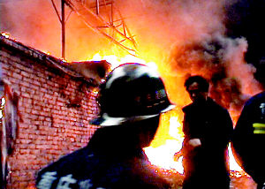 简易厂房被烧 工人叼着香烟看消防队灭火