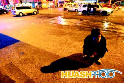 夜幕下的晓光无助地蹲在马路上