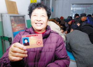 图为张俊银老人高兴地领到了"夕阳红就医优惠卡".本报记者张震摄