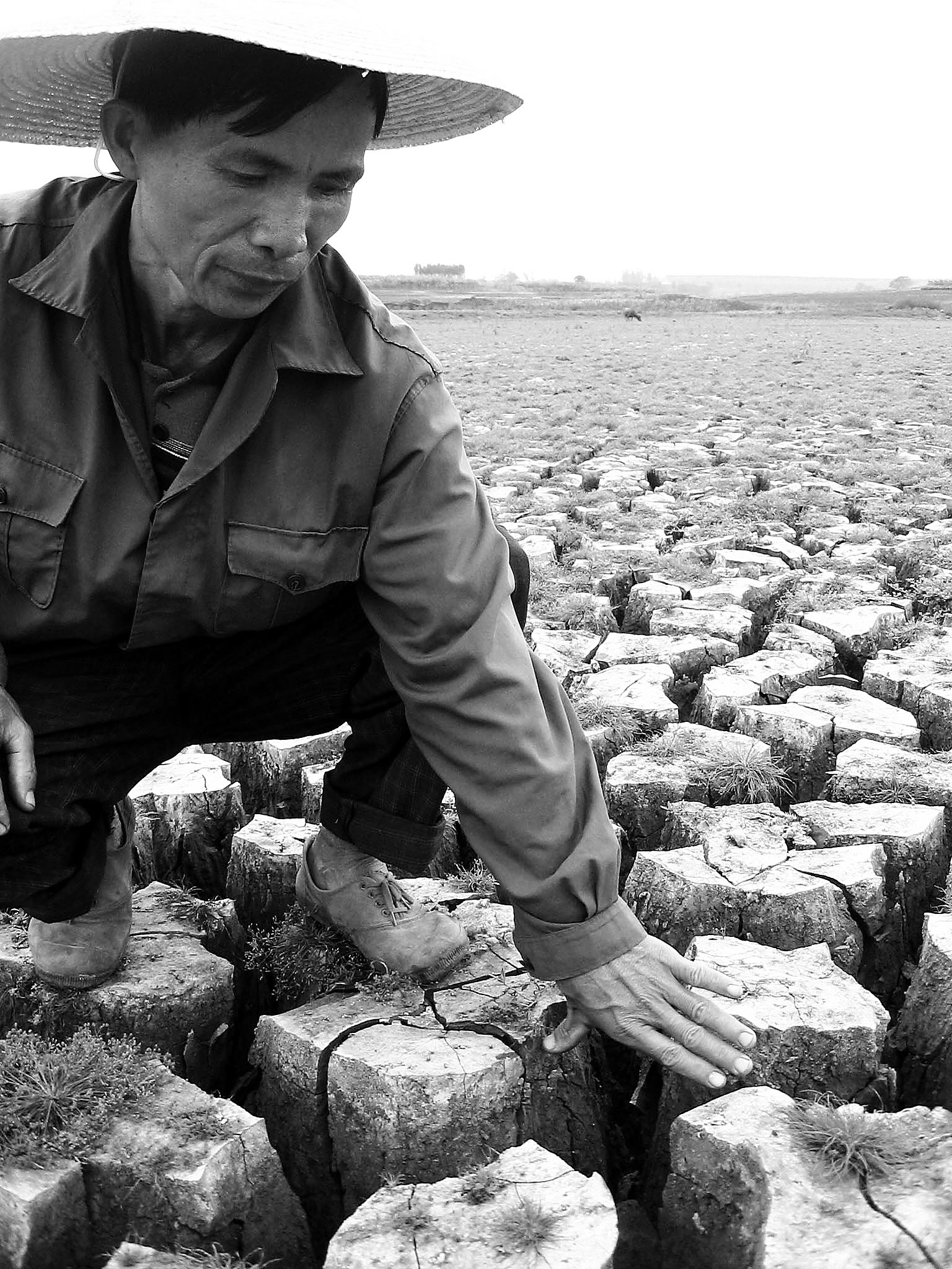 2月21日,在雷州半岛旱情最严重的广东省徐闻县,一名农民用手比量干涸