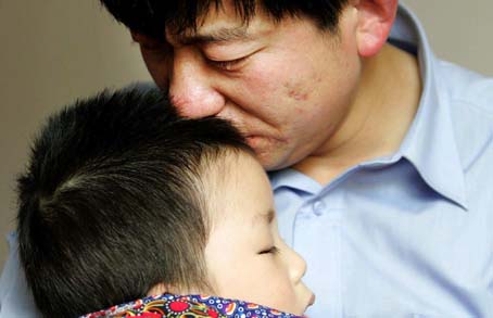孟振华悲伤地握着儿子的手