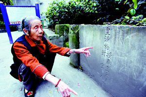 图为88岁的王婆婆在说古墓碑年代久远