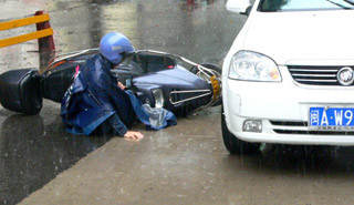 雨天太滑 女骑手摔倒 男士"救美"