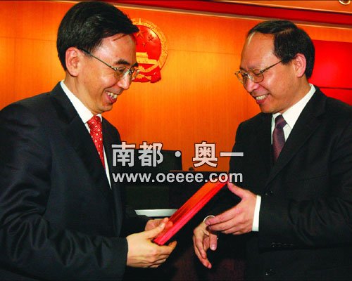 广州市人大主任朱小丹(左)给新任广州市政府秘书长陈如桂颁发任命书.