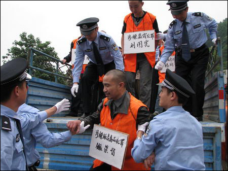 2007年6月26日,一名贩卖毒品犯被从车上押往公捕公判大会现场.