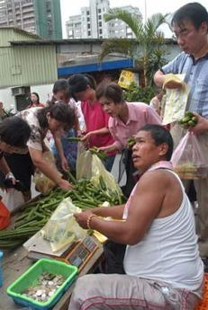 图文：台湾小贩赶在台风到来前出售蔬菜