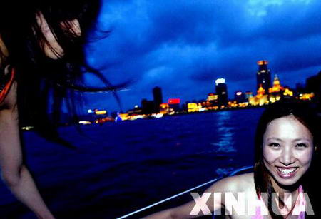 图文：在上海黄浦江上的游客被大风吹散了长发
