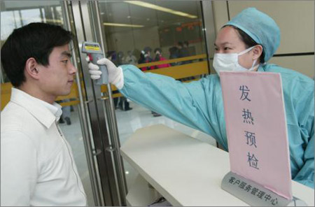 华山医院/在上海复旦大学附属华山医院，医生正在为一名“患者”测量体温...