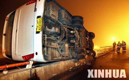 天津/12月29日，发生事故的大客车“侧躺”在立交桥的护栏上。新华...