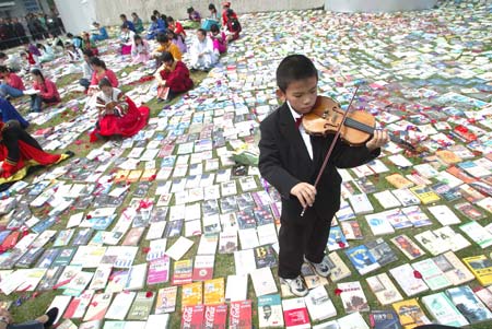 图文:小演奏家在书堆里拉小提琴