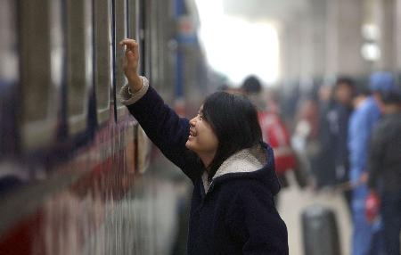 图文:一位姑娘在南宁火车站与亲友挥手告别