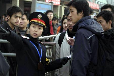 图文:西安火车站工作人员在引导旅客进站