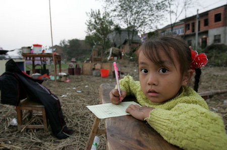图文:九江地震后小朋友在田地里做作业
