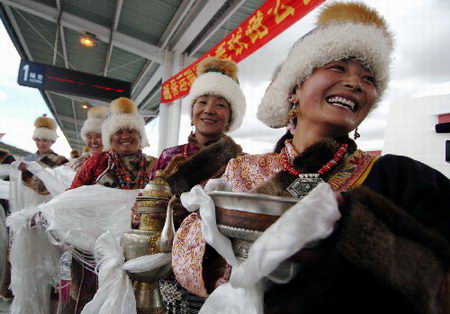 图文:列车通过安多火车站-藏族妇女手持青稞酒