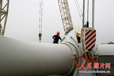 组图:江苏首台风电机组在如东海滩吊装成功