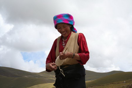 这位藏族妇女在山顶最高处(海拔应该有5000米
