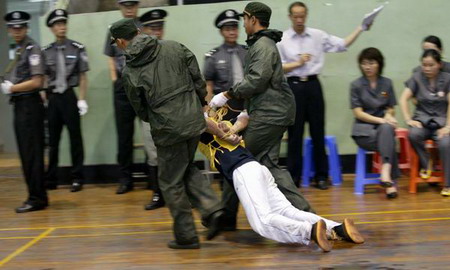 图文:假装晕倒的死刑犯被武警押走