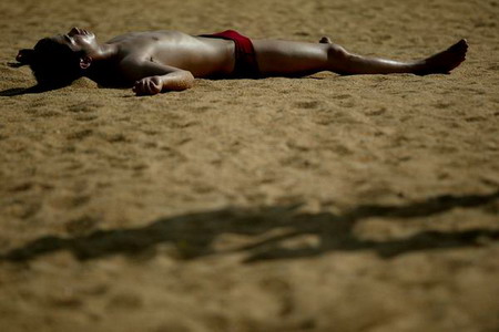 图文:游客在珠海市海滨泳场的沙滩上晒太阳