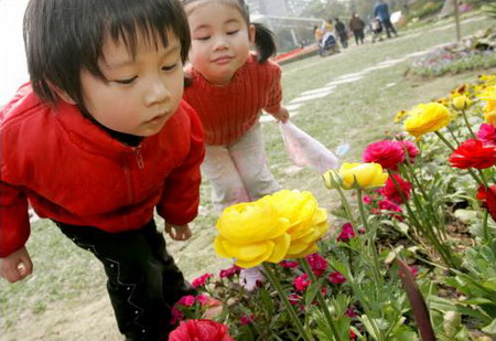 两位小朋友正靠近盛开的鲜花仔细观赏上海植物园内盛开的鲜花2007年4