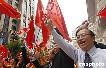 图:香港市民挥舞国旗祝贺神舟五号飞船成功发