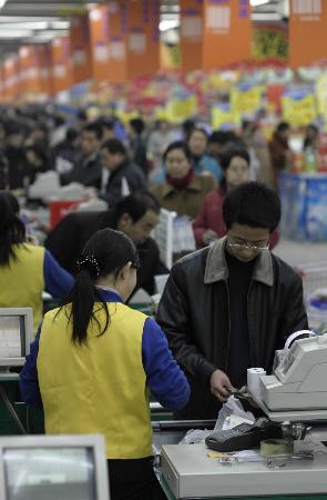 2005年2月11日,顾客在太原山姆士超市建南店收银台排队付款.