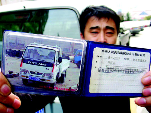 记者展示他的机动车行驶证,图中白色的车就是在停车场丢失的福田货车