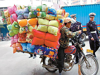 一辆摩托车载50多个枕头(图)
