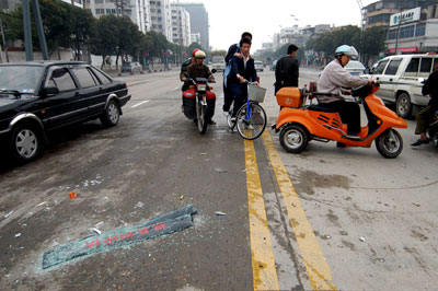 (图)几名骑车市民违章左拐,右边是一辆刚刚因违章调头而发生事故的