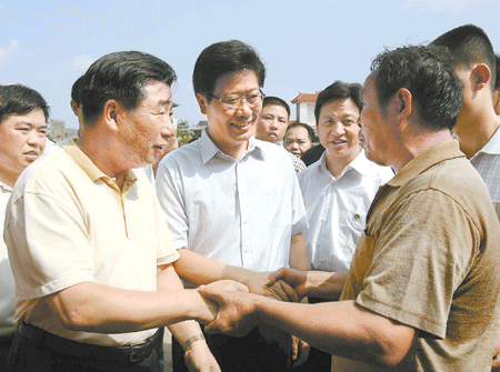 7月18日,回良玉在耒阳市三都镇坪洲村看望受灾群众.