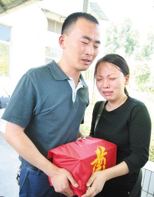 5月11日,在惠州市殡仪馆内,杜某和丈夫王先生抱着女儿梦雨的骨灰盒