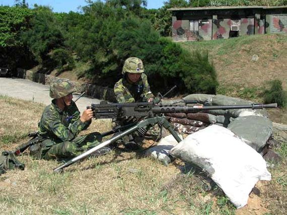 图片说明:两名台军士兵操纵12.7毫米重机枪准备射击