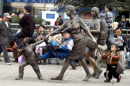 图文:火车站广场上不文明--旅客在雕塑上攀爬