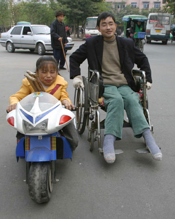 丈夫高位截瘫坐轮椅 残疾妻子个矮开儿童电瓶车