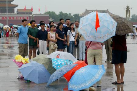 图文：游客们在雨中的天安门广场拍照留念