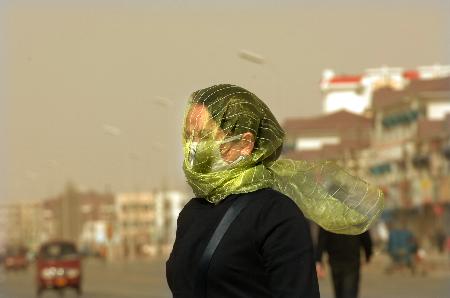 图文:市民将纱巾套在头上遮挡沙尘