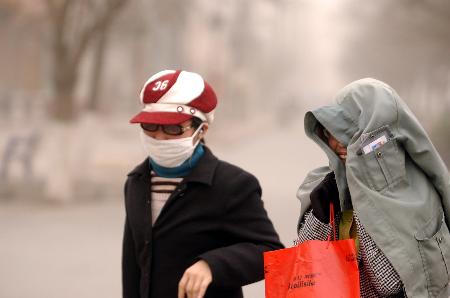 图文:甘肃省白银市的两位市民在沙尘中行走