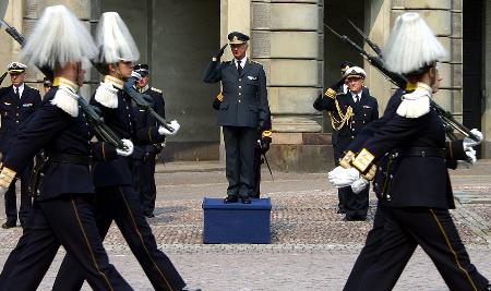 的瑞典国王卡尔十六世·古斯塔夫(中)在斯德哥尔摩的王宫检阅皇家卫队