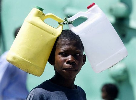 图文:美洲最穷国家海地街头扛着水桶的男孩