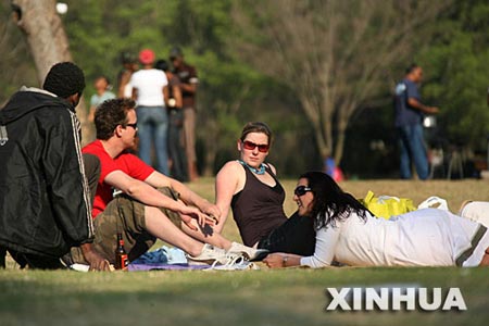 9月24日,在南非约翰内斯堡的动物园湖公园,几名年轻人在草地上休息.