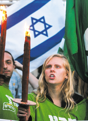 以色列人举着火把和国旗在总理奥尔默特位于耶路撒冷的宅邸外抗议