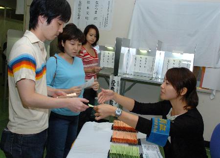 图文:选民在东京涩谷的一处投票站领取选票