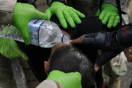 资料图片:美伊士兵在巴格达为受伤男孩洗头部