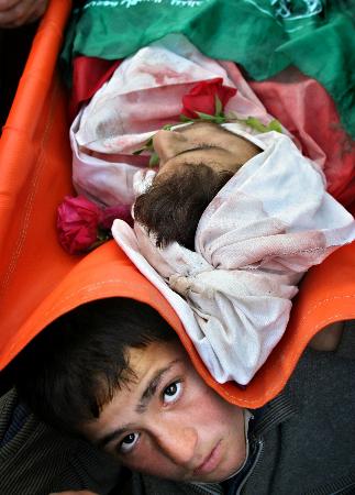 图文：一名巴勒斯坦男孩抬着弟弟的尸体