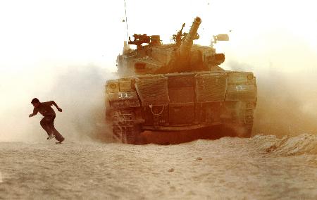 图文：一名巴勒斯坦男孩躲开以军坦克